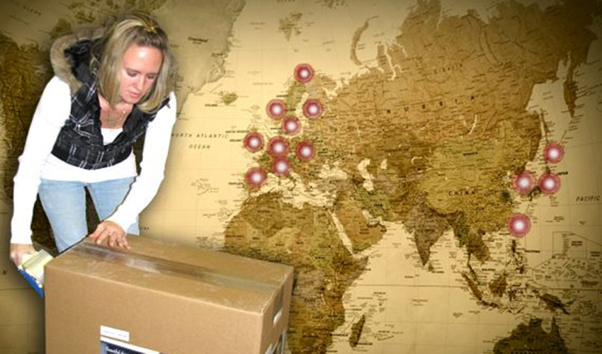 Natasha taping up a Condar package in front of a map of the world
